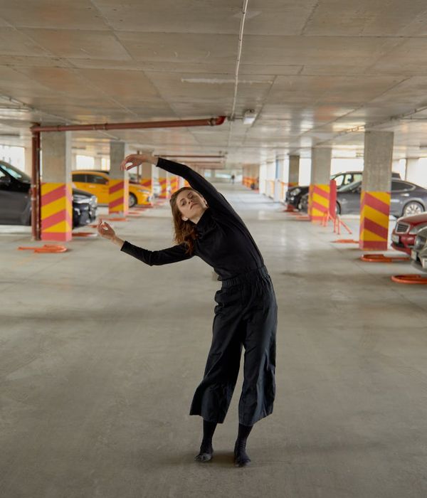 Woman performing a fluid cardio movement in a bright space.